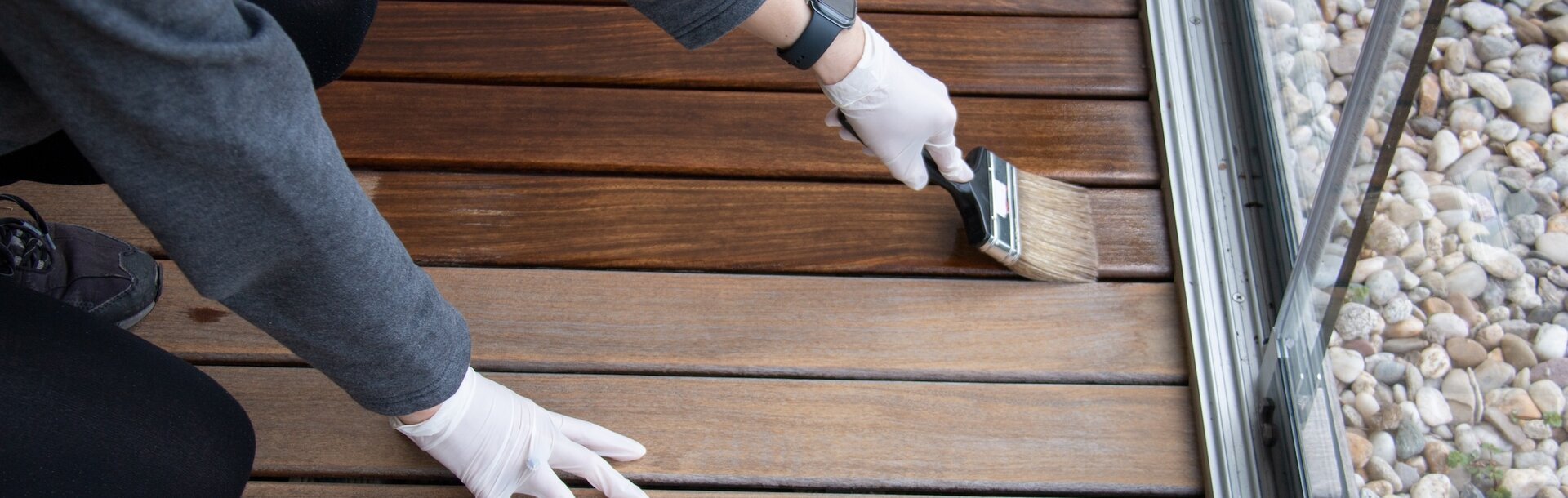 2251442001 | Worker refinishing wood, hand painting wooden deck floor with wood protection oil 2251442001 | Worker refinishing wood, hand painting wooden deck floor with wood protection oil
